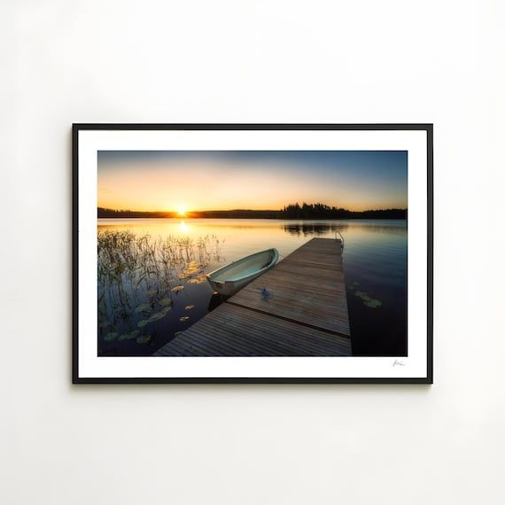 Skandinavischer See bei Sonnenaufgang mit Steg und Boot in einem Rahmen